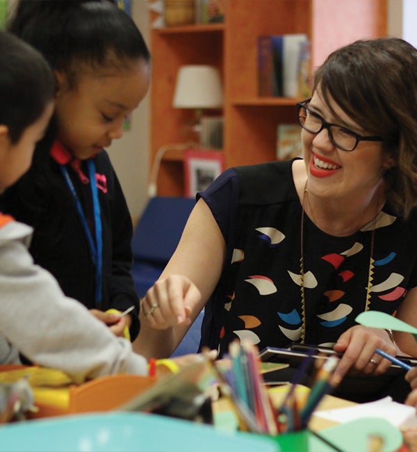 Teacher working with student at desk